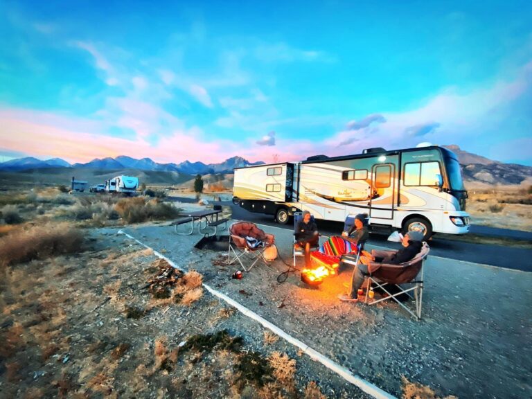 RV campground with people relaxing in front of a campfire