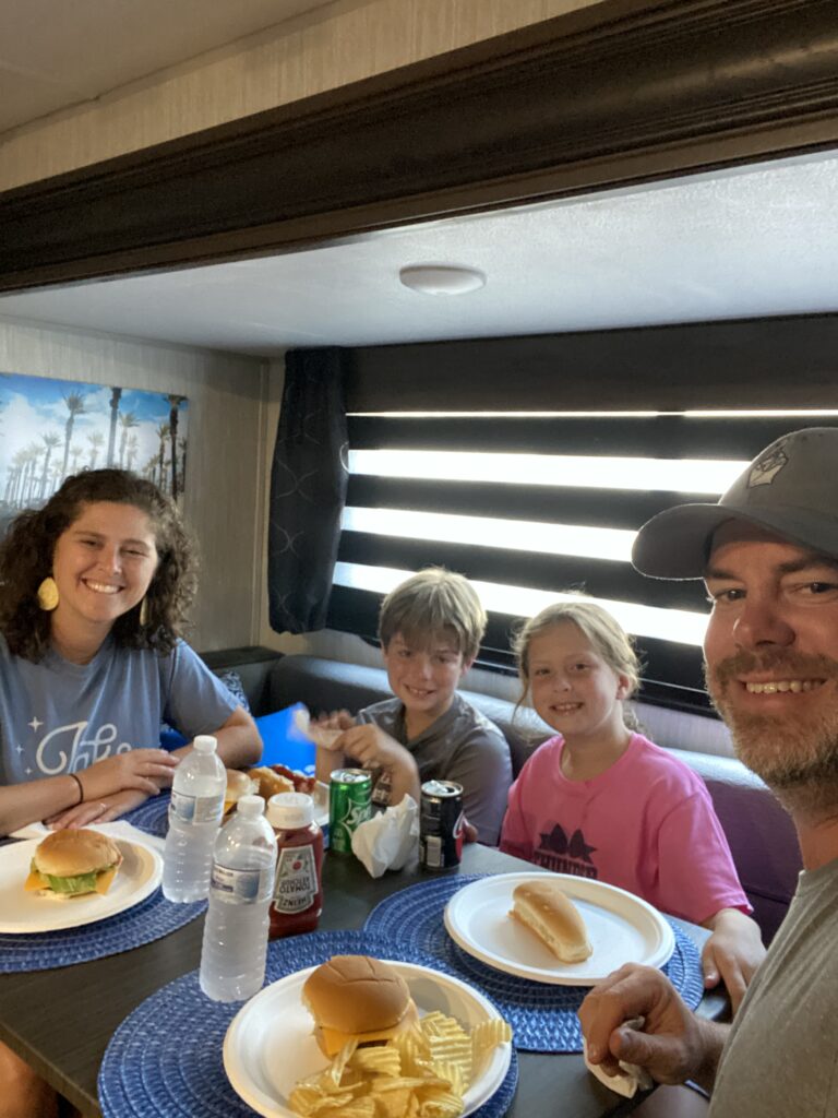 kids and parents eating around an RV table