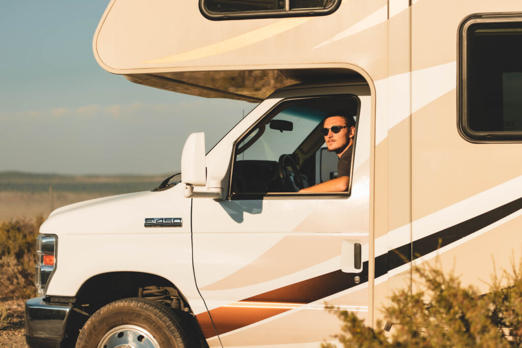 a man looking out of an RV driver's side window