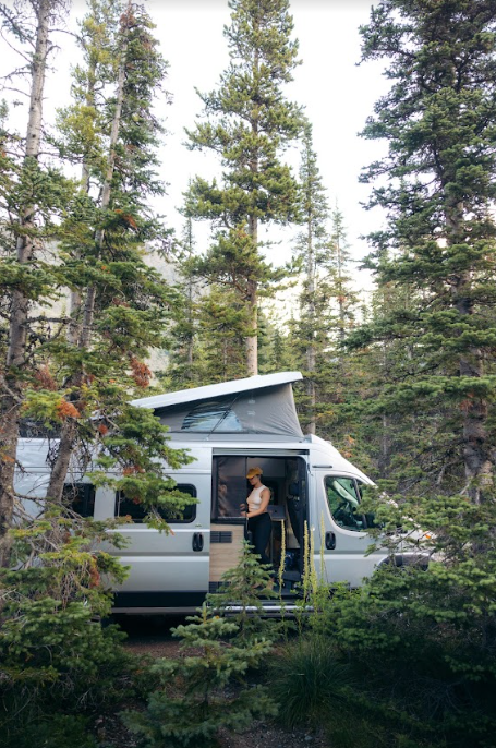 A woman in a campervan in a forest