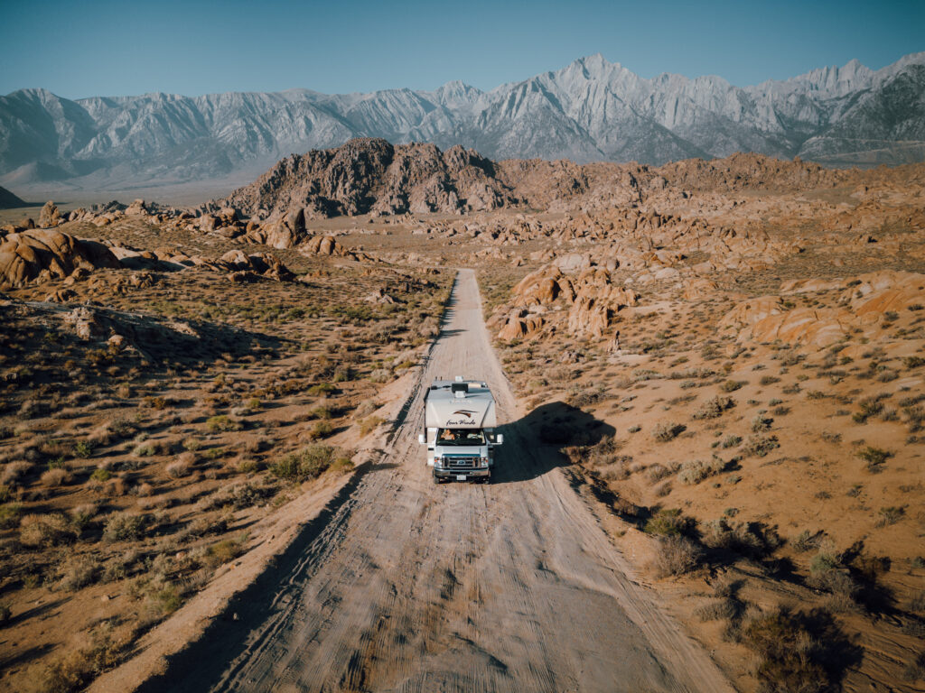 An RV on a rocky road near mountains