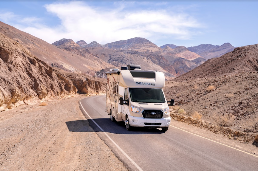 A Class C camper on a desert road
