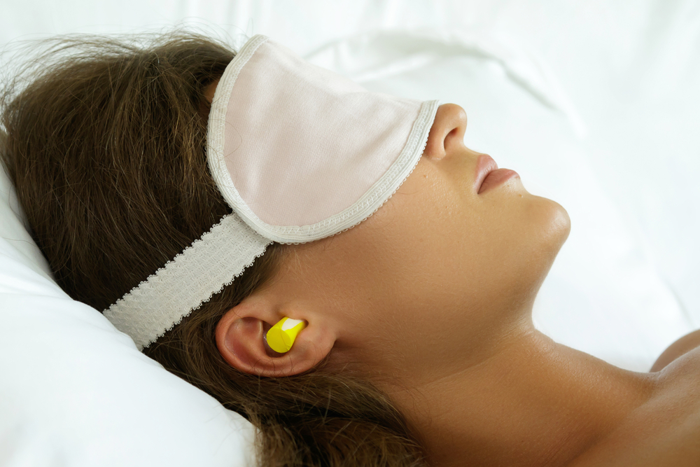 a woman with earplugs and a face mask
