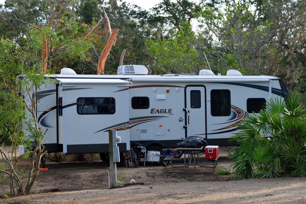 a fifth wheel trailer at a campground with palm trees