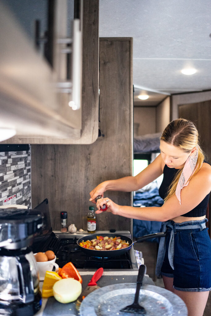a woman cooking in an RV kitchen