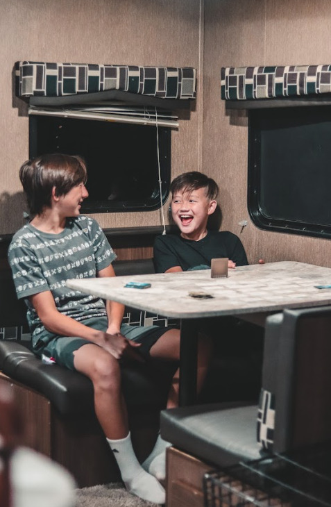 kids sitting at a table in RV laughing