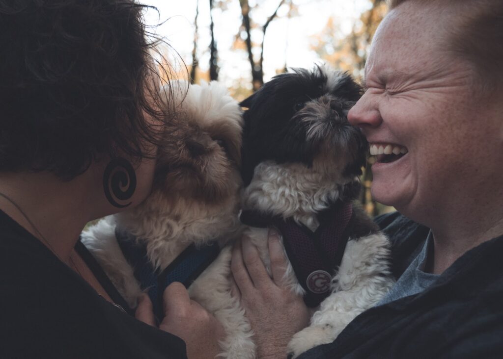 Couple shares a laugh while holding their two dogs