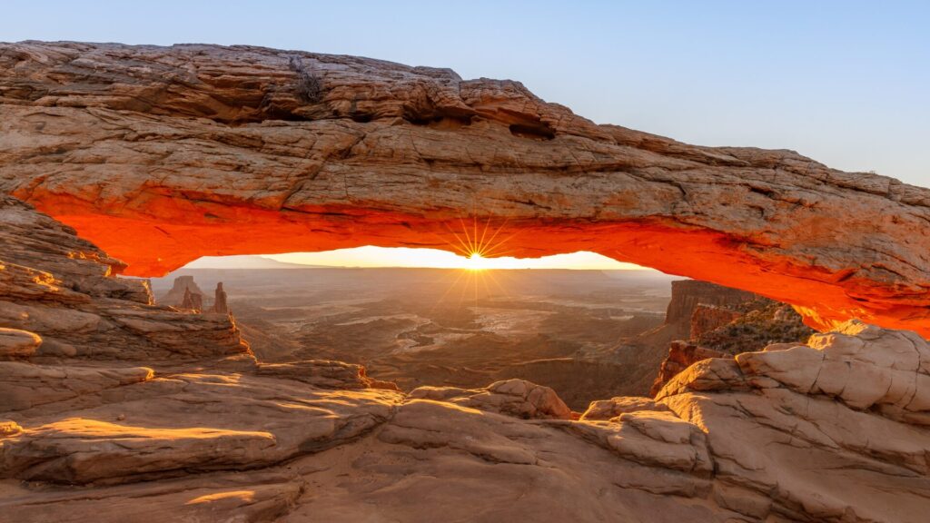 Sun behind arch in Moab